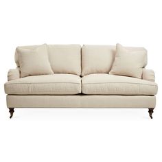 a white couch with four pillows on it's back and two sides facing each other