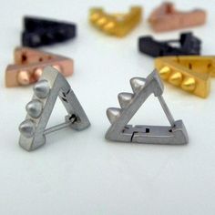 several different colored metal clips on a white surface