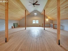 an empty room with wooden floors and ceiling fans