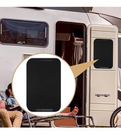 a man sitting in a chair next to a trailer with the door open and an rv parked behind him