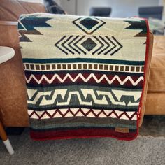 a blanket sitting on top of a couch next to a chair