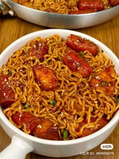 two bowls filled with noodles and meat on top of a wooden table next to each other