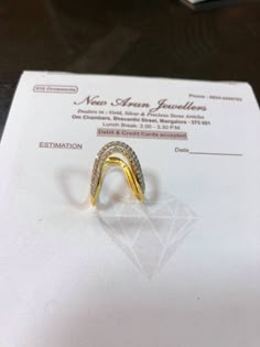 a yellow and white diamond ring sitting on top of a piece of paper