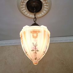 a light fixture hanging from the ceiling in a room with beige walls and flooring