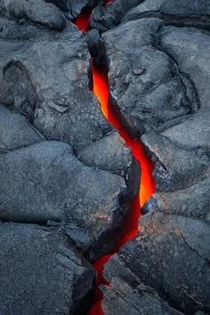 lava flowing down the side of a mountain with bright red flames coming out of it