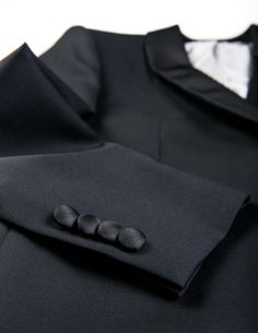 For those who opt for silk grosgrain trim on their tux instead of satin, this tuxedo reads very classy and classic. Whatever your black-tie occasion, this tuxedo will serve you well. FABRIC AND TRIMS: Super 110s wool plainweave woven in Italy by Vitale Barberis Canonico 9.17 Oz Weight SEASONALITY: Suitable for year-round use in most climates COLOR: Black BUTTONS: Covered in accent fabric ACCENT FABRIC: Black grosgrain on lapel, hip pockets, and buttons LINING: Fully lined in gray/white stripe CO