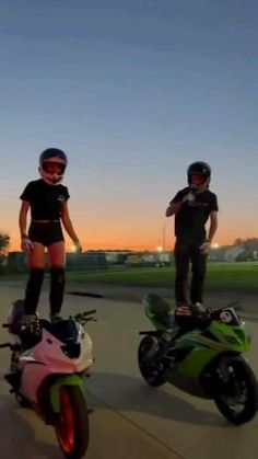 two people standing next to each other on motor scooters and one person wearing knee pads