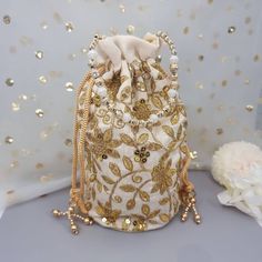 This Potli Bag goes well with both Indian and Western outfits and is superb for Wedding and Festive parties wherein it will best complement your Designer Saree, Lehnga or any other dress. Being lightweight, these bags can easily be wrapped around the wrist using their drawstrings. You can easily keep your personal belongings like Money, Mobile, Cosmetics easily in that. It can be one of the best gifts for any woman. They will just love it. Product Dimensions Length: 23cm Witdh: 12cm Product Care: Gentle Hand Wash/Closure Type: Drawstring/Outer Material: Silk, Inner Material: Other We try to take pictures as normal as we can but colors may slightly vary due to different lighting setups. Please note: No Returns No Exchange. But If you have any issue with your order, Kindly contact us before Embroidered Gold Potli Bag, Festive Embroidered Beige Potli Bag, Festive Gold Pouch Potli Bag, Festive Gold Potli Bag With Handwork, Gold Pouch Potli Bag For Festive Occasions, Gold Pouch Bag With Dori Work, Gold Pouch Potli Bag For Diwali, Gold Bags With Dori Work For Gifts, Gold Embroidered Potli Bag For Gift