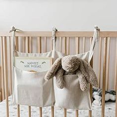 a stuffed animal sitting on top of a baby crib next to a book bag