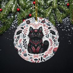 a black cat ornament hanging from a christmas tree