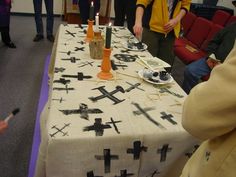 people standing around a table with candles on it