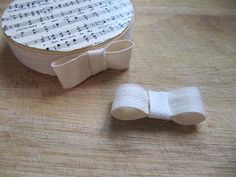 a pair of white bow ties sitting on top of a wooden table