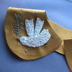 a piece of cloth with an embroidered bird on it