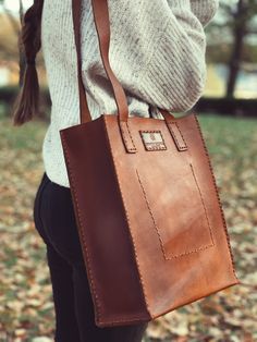 Carefully crafted and stitched by hand in the highlands of Ecuador with full grain leather. The natural imperfections of the leather make each piece unique and full of character. Our Leather Tote bag was designed in small batches to withstand the everyday use, from a walk to the park to a long day at work. Bring all your favorite essentials and get ready for a lifetime of adventures. Measurements: Size 14" (35.56 cm) tall x 12" (30.48 cm) wide x 5" (12.7 cm) deep **Leather is a natural material Rectangular Vegetable-tanned Satchel For Daily Use, Cognac Vegetable-tanned Satchel Bag, Vegetable-tanned Cognac Satchel Bag, Brown Vegetable-tanned Rectangular Bag, Brown Rectangular Vegetable-tanned Bags, Fall Satchel Bag With Leather Backing, Fall Leather-backed Satchel Bag, Natural Leather Bag Vegetable-tanned, Natural Leather Shoulder Bag With Double Handle