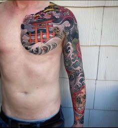 a man with a tattoo on his chest and arm is standing in front of a wall