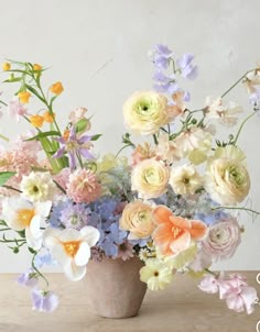 a vase filled with lots of different colored flowers