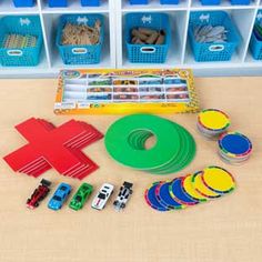 toy cars and other toys sitting on a table in front of bins with plastic dividers