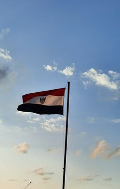 a flag flying high in the sky on a sunny day