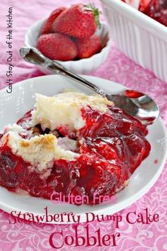 strawberry dump cake cobbler on a pink tablecloth with strawberries in the background