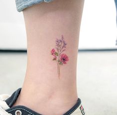 a small flower tattoo on the ankle