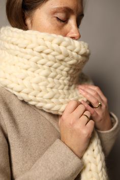 a woman wearing a white knitted scarf