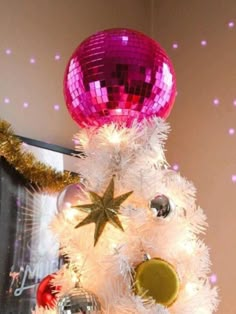 a white christmas tree decorated with pink and gold ornaments, disco ball ornament