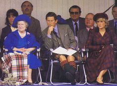 the queen and prince are sitting next to each other in front of people wearing hats