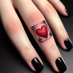 a woman's finger with a heart in a glass tattoo on her left hand