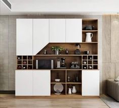 a kitchen with white cabinets and wooden flooring in front of a wall mounted oven