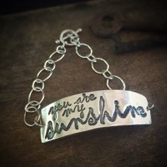 "\"You Are My Sunshine\". Are you singing already? This bracelet is a little piece of happy. This bracelet is lovingly made from recycled fine silver, and 2 sets of sterling silver chain. It is finished with a toggle clasp. The silver artwork charm is approximately 1 3/4 inches across and 1/2 inch wide. If you require a bracelet size other than a standard 7 inches, simply leave me a note during checkout with your desired size. Not familiar with fine silver? Here are the facts: Fine silver has a Everyday Handmade Name Bangle Bracelet, Handmade Everyday Name Bangle Bracelet, Inspirational Handmade Name Bracelet For Everyday, Handmade Everyday Name Bangle, Everyday Inspirational Handmade Name Bracelet, Inspirational Handmade Name Bracelet, Personalized Bohemian Bracelets For Friendship, Bohemian Personalized Bracelets For Friendship, Inspirational Handmade Bracelets For Everyday