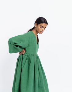 Oversized midi dress in basil green color, handwoven from cotton fabric by women artisans of India's western region. Versatile design for year-round wear. Subtle gathers at the waist for added contour to the boxy fit. Ideal for transition weather and semi-formal occasions. Midi Dress With Gathered Neckline For Gatherings, Green Knee-length Midi Dress With Gathered Sleeves, Billowy Green Dress, Oversized Green Midi Dress, Green Cotton Midi Dress For Daywear, Green Cotton Dress With Gathered Sleeves, Green Relaxed Fit Midi Dress For Daywear, Green Spring Dress With Gathered Skirt, Spring Green Dress With Gathered Skirt