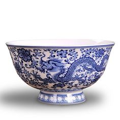 a blue and white porcelain bowl with dragon designs on the rim, sitting in front of a white background