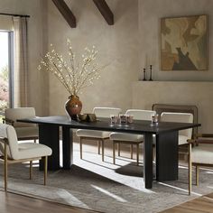 a dining room table with chairs and a vase filled with flowers on top of it