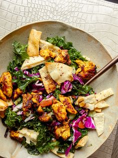 a salad with tofu, lettuce and red cabbage on a white plate