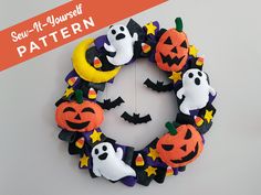 a halloween wreath made out of felt with bats, pumpkins and ghost faces on it