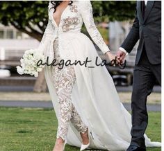 the bride and groom are walking together in their wedding attire, holding hands with each other