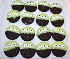 green and black cupcakes with googly eyes are on a white platter