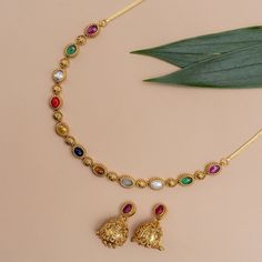 Description: Experience the fusion of tradition and contemporary elegance with our Navratna Necklace. Each of the nine vibrant Navratna gemstones is studded in a string to make your style classic and minimal. This piece pays homage to India's rich cultural heritage and spiritual significance, symbolizing the auspiciousness of each Navratna gem. Details & Specifications: Materials used: Brass Alloy with Antique Gold Platting Weight -Necklace-18.50 gm, Earrings-15.85 gm Length - Necklace-9.5 cm, E Simple Navaratna Necklace, Festive Multi-stone Gold Necklace, Round Gemstone Temple Necklace For Festive Occasions, Hand Set Multicolor Bridal Necklace, Multicolor Hand Set Bridal Necklace, Elegant Multicolor Gemstone Temple Necklace, Spiritual Round Necklaces For Festive Occasions, Festive Spiritual Round Necklace, Festive Spiritual Multicolor Temple Necklace