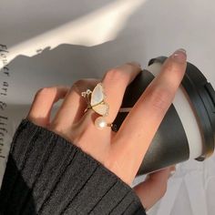 ✦ Embrace the romantic feel of a fairy garden with this elegant and sacred pearl and ivory ring, adorned with tiny inlaid zircon. A perfect hue of gold adds a touch of sophistication, making it the perfect accessory for any occasion. From bridesmaids to sisters, this cocktail split ring is a heartfelt gift that will be cherished for years to come. Add a touch of magic to your dinner parties or nights out with this exquisite piece. ----------- DETAILS ----------- - Color: Gold, Ivory - Ring Size: Adjustable - Materials: Gold Plated, Faux Pearl, Cubic Zirconia - SKU: K4113 White Elegant Rings, Elegant Open Crystal Ring For Proposal, Elegant Gold Flower Ring For Proposal, Delicate White Jewelry For Proposal, Cubic Zirconia Opal Ring For Wedding, Elegant Opal And Cubic Zirconia Promise Ring, Dainty White Moonstone Wedding Ring, Elegant White Crystal Proposal Ring, Delicate White Proposal Ring