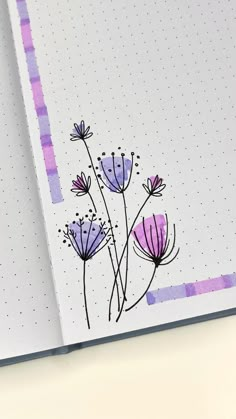 an open notebook with flowers drawn on the cover and dotted lines in the back ground