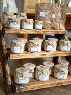 many jars are stacked on wooden shelves with brown paper wrapped around them and tied in twine