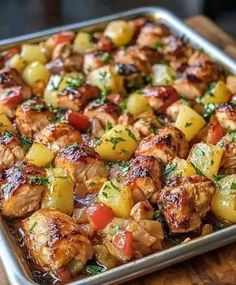 a pan filled with meat and vegetables on top of a wooden table