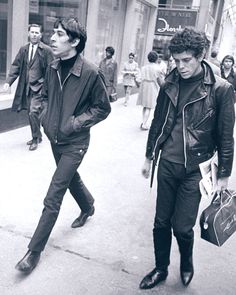 black and white photograph of two men walking down the street