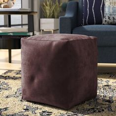 a living room with a blue chair and brown ottoman