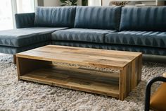 a living room with a blue couch and wooden coffee table