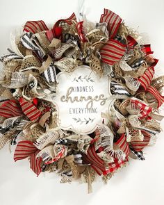 a red, white and black wreath with the words kindness change everything written on it