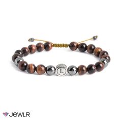 This men’s bracelet with red tiger eye and hematite beads features an engravable circle charm. It is designed with an adjustable sliding knot for comfort and ease. Personalize with an initial for a special touch.