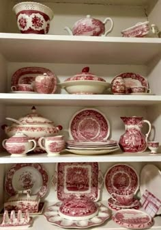 red and white china is displayed on shelves