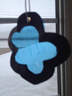 a black and blue flower hanging from a window