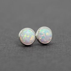 These opal stud earrings are beautiful.  They feature a single 6mm simulated opal cabochons.  Hand bezel set in my studio.  6mm Simulated Opal Round CabochonsSolid 925 Sterling Silver or 14/20 Gold FilledArtisan Made in TexasArrives thoughtfully packaged in a signature jewelry boxCheck out all of my opal earrings: https://www.etsy.com/shop/KMBankston/search?search_query=opal+earring&order=date_desc&view_type=gallery&ref=shop_search~About Me:My name is Kathy Bankston, and I am a metal Dainty Opal Cabochon Jewelry, Classic Opal Cabochon Jewelry, Classic Opal Jewelry As A Gift, Classic Opal Jewelry For Gifts, Minimalist Ethiopian Opal Round Jewelry, Iridescent Opal Jewelry For Anniversary, Iridescent Round Opal Jewelry, Iridescent Opal Round Jewelry, Hypoallergenic Round Opal Jewelry